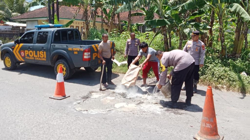 Cegah Kecelakaan, Polsek Cikalong Tasikmalaya Tambal Jalan Berlubang secara Darurat