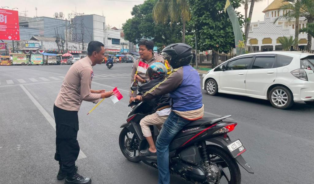 Tumbuhkan Patriotisme, Polsek Tawang Bagikan Ratusan Bendera Merah Putih kepada Pengendara di Depan Masjid Agung Tasikmalaya